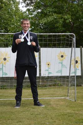 Vocational student shows off Pan Ability Football Cup Medals